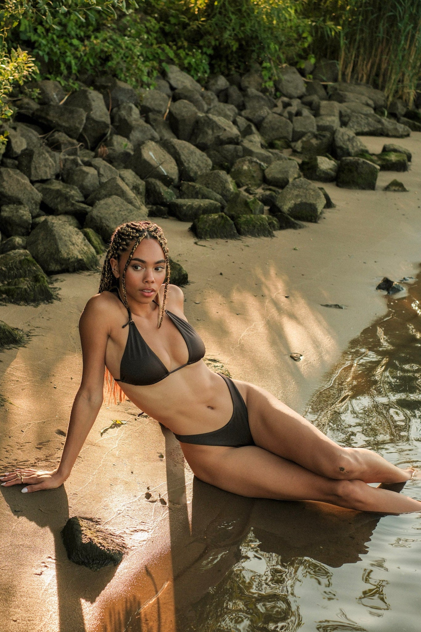 vrouw in bruine bikini zittend in zand 