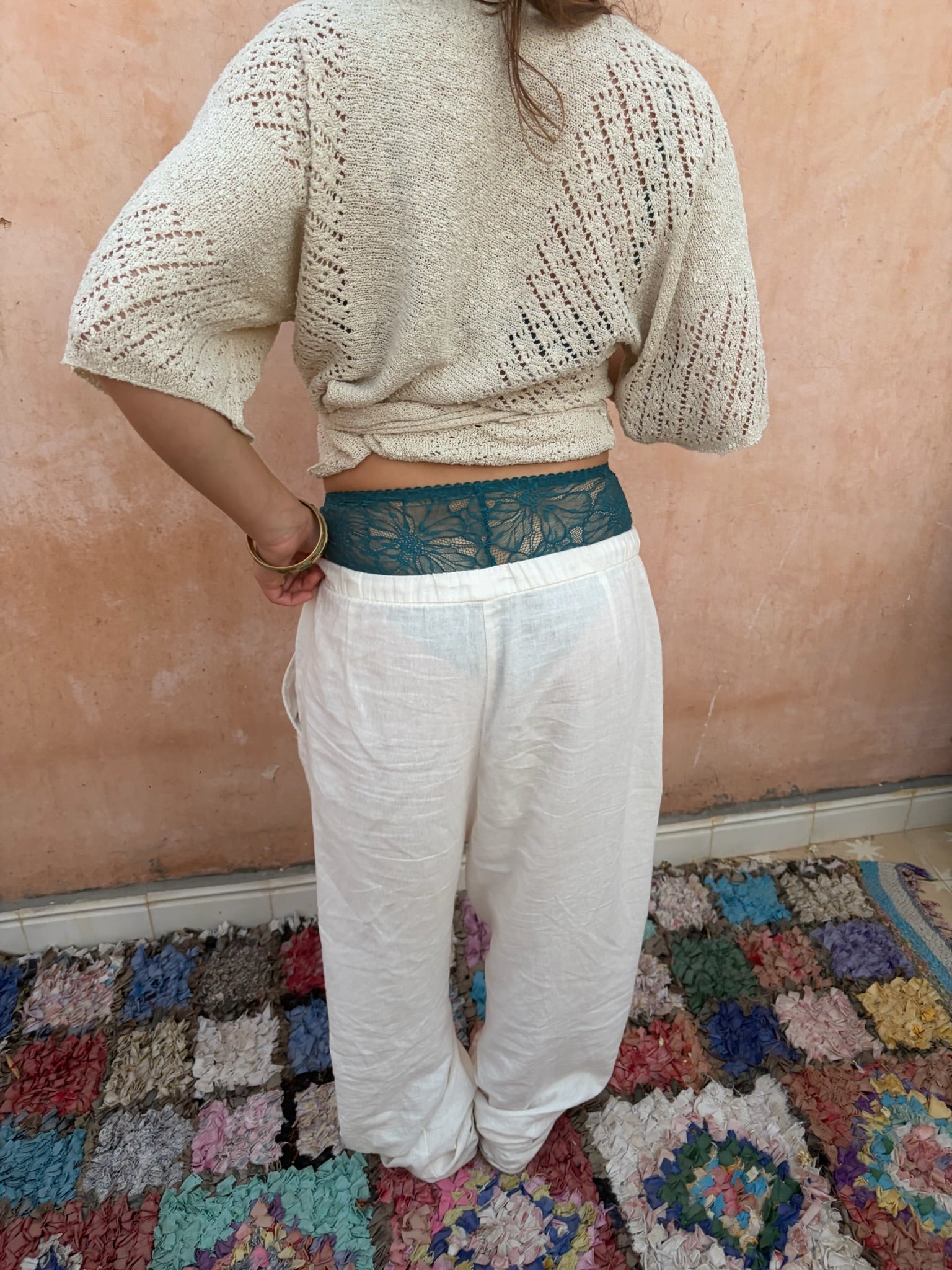 foto achterkant witte linnen broek en gehaakte top met blauw lingerie broekje die uitsteekt