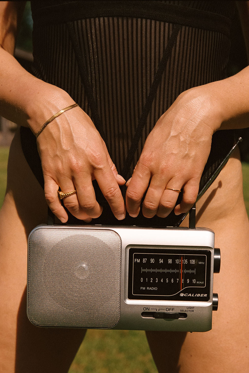 radio voor lichaam met gouden sieraden en in zwart gestreept lingerie bodysuit 