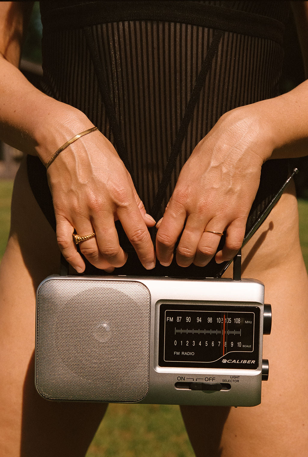 radio voor lichaam met gouden sieraden en in zwart gestreept lingerie bodysuit 