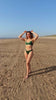 linda de munck poserend in groene bikini van pavo couture op strand 